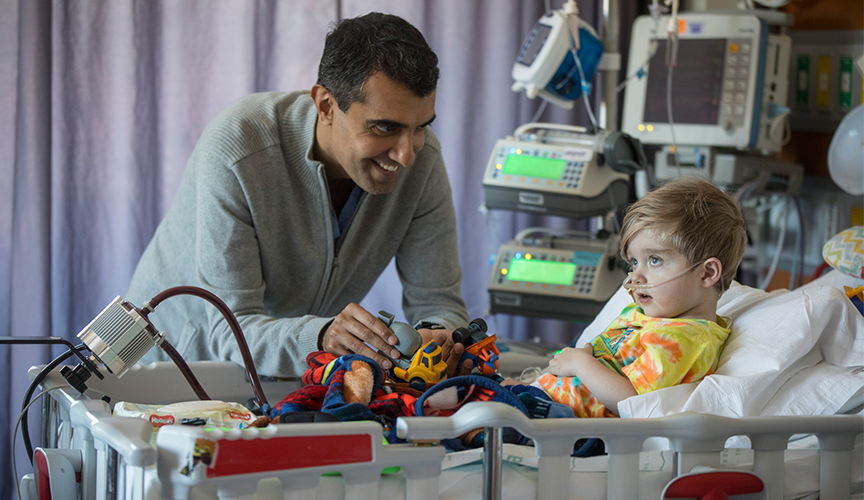 A Le Bonheur pediatric cardiology fellow, Neil Tailor, interacts with a CVICU patient, Lincoln Hopper.